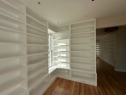 White floor-to-ceiling library shelving