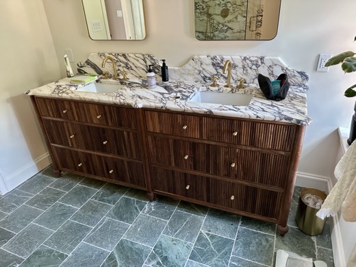 Walnut fluted double vanity with marble top and brass fixtures